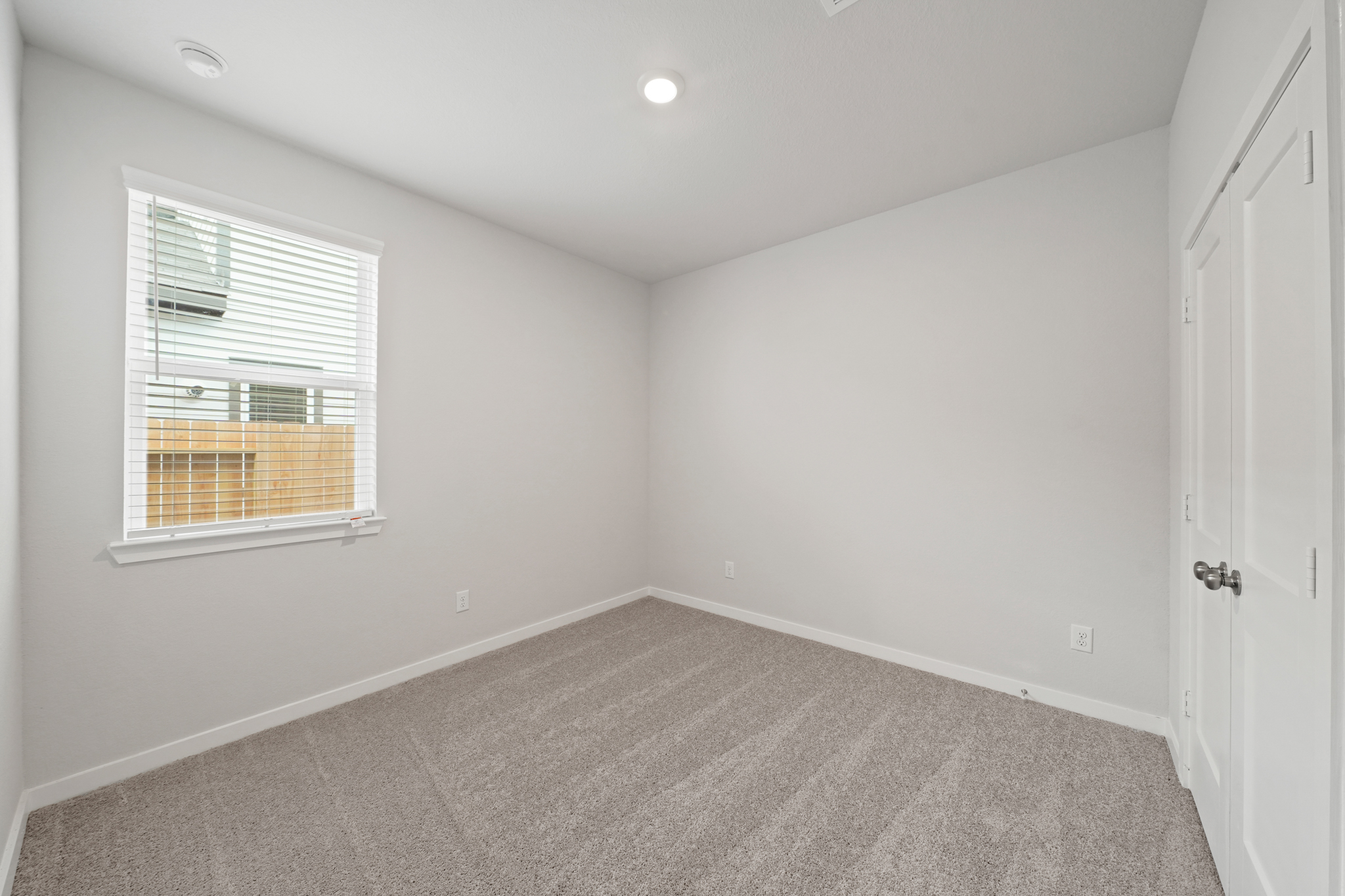 A room with a window and a carpet.