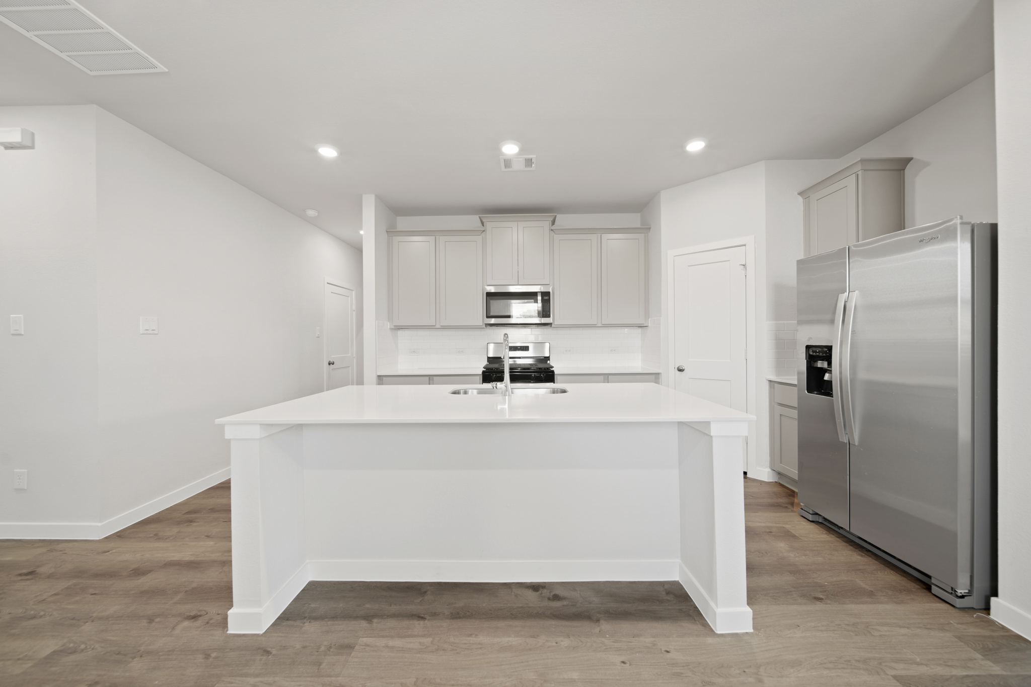 A kitchen with white cabinets.