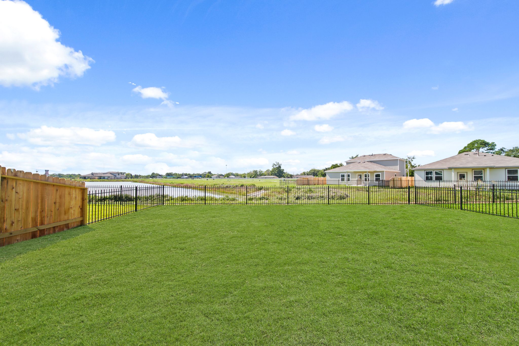 A fenced in yard with houses in the background.