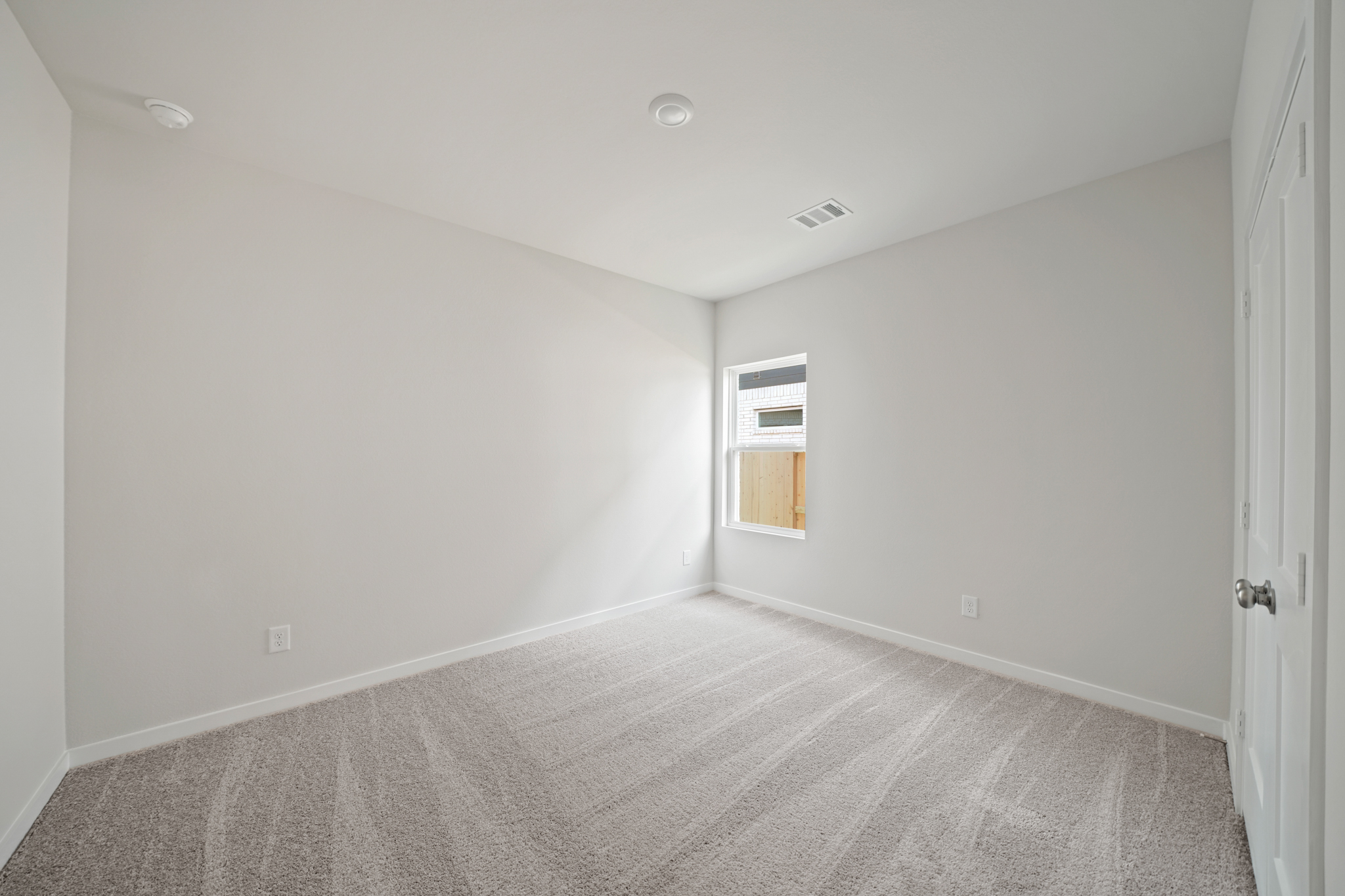 A room with a carpet and a door.