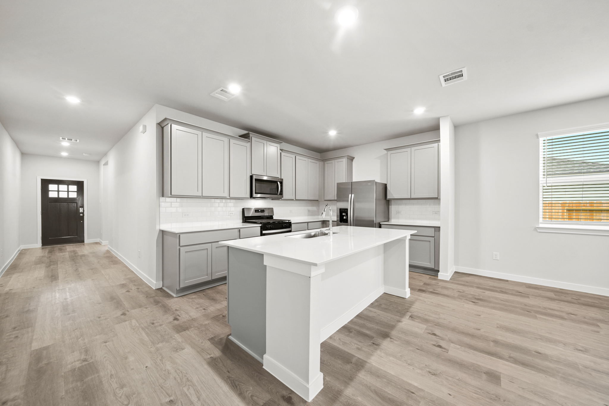 A kitchen with white cabinets.
