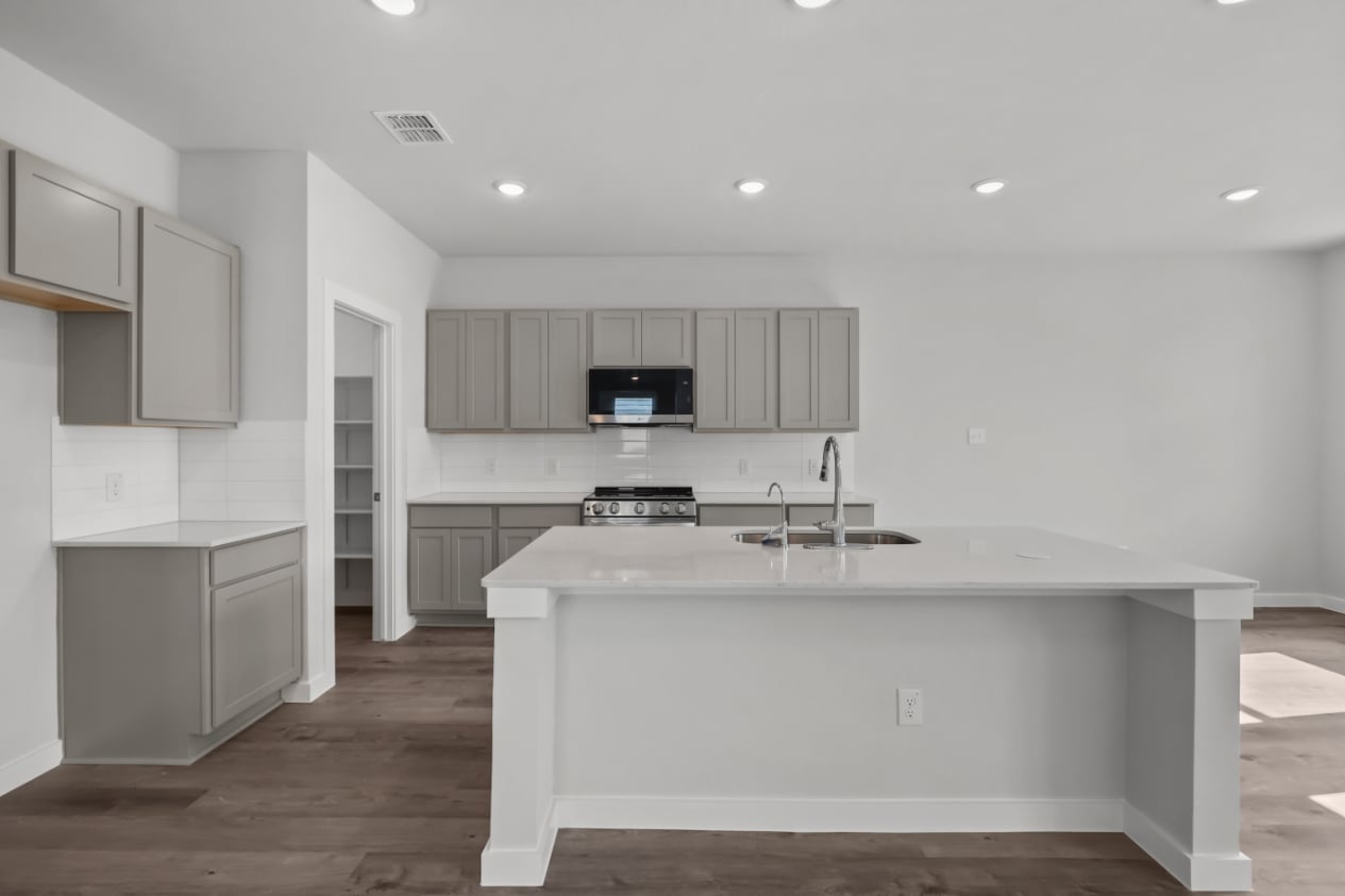 A kitchen with white cabinets.
