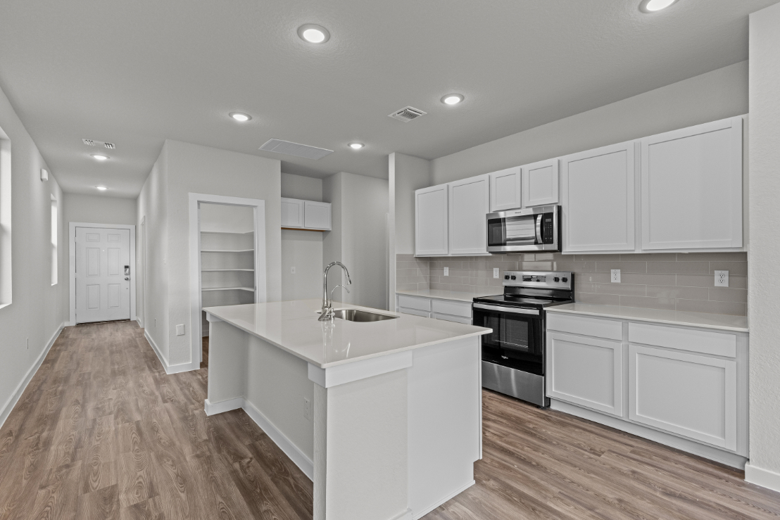 A kitchen with white cabinets.