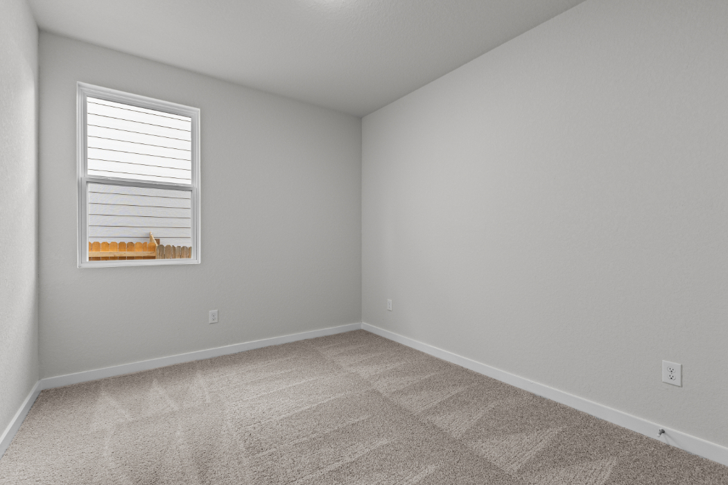 A room with a window and carpet.