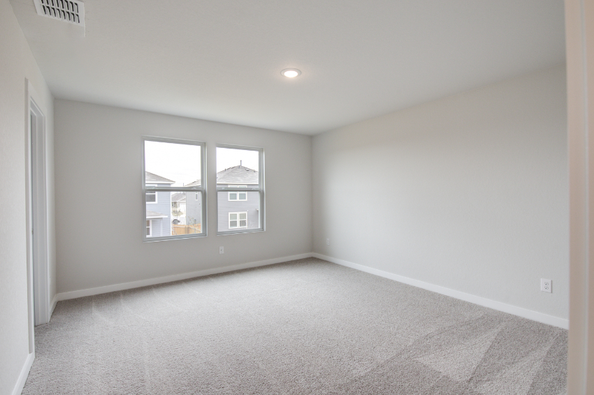 A room with a window and a carpet.