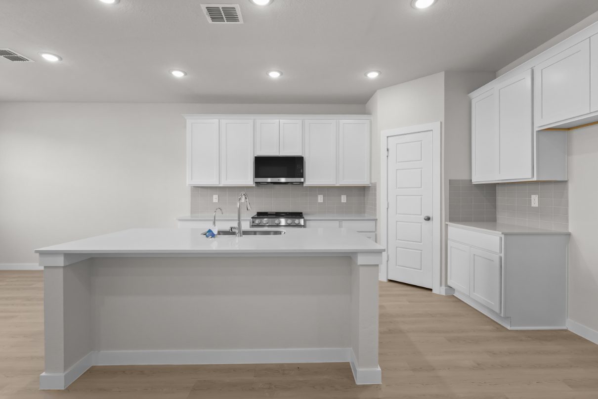 A kitchen with white cabinets.
