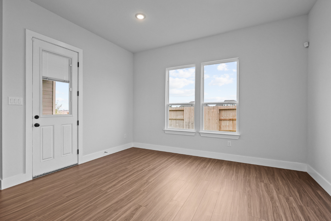 A room with a wood floor and a white door.