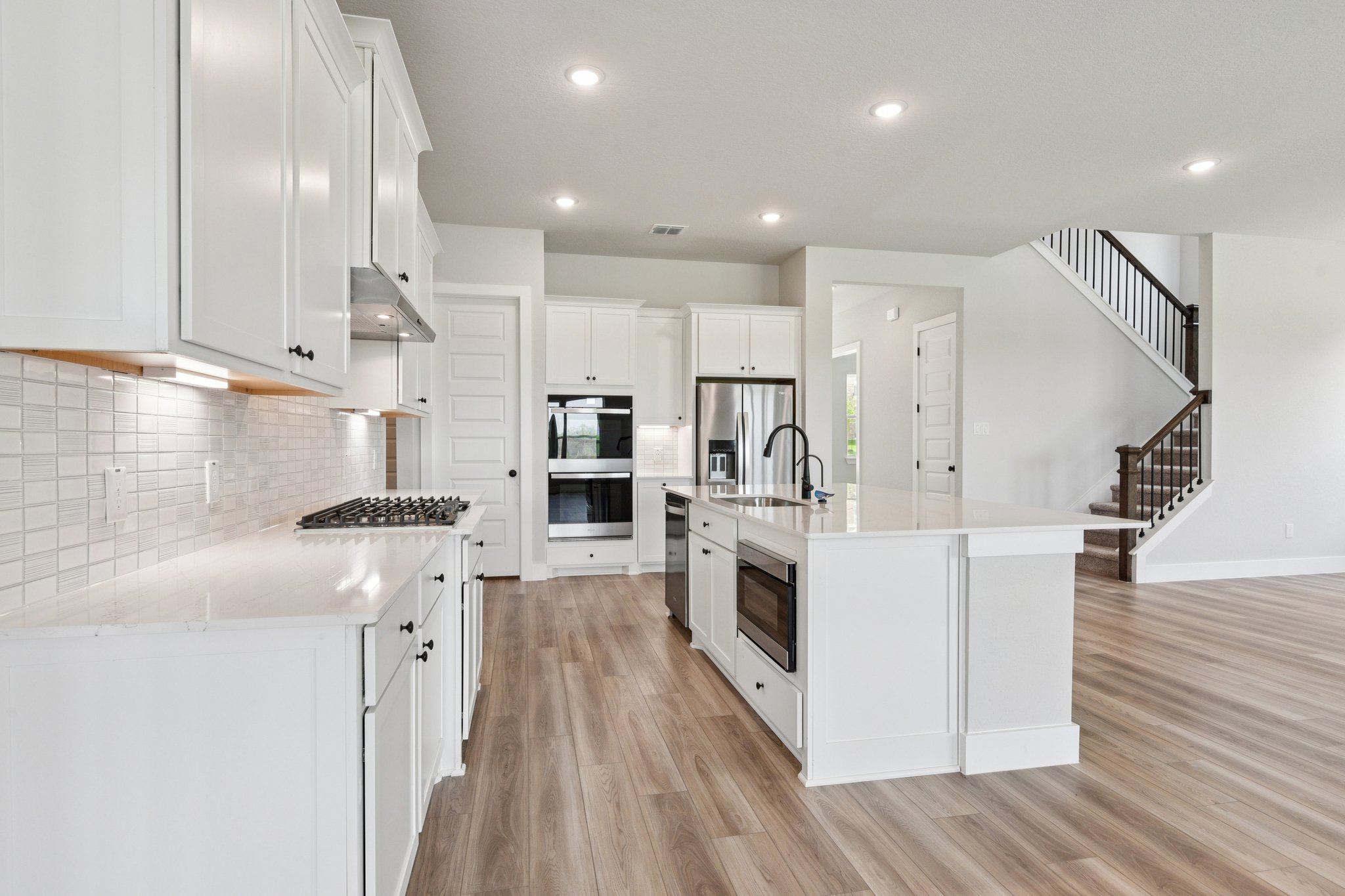 A kitchen with white cabinets.