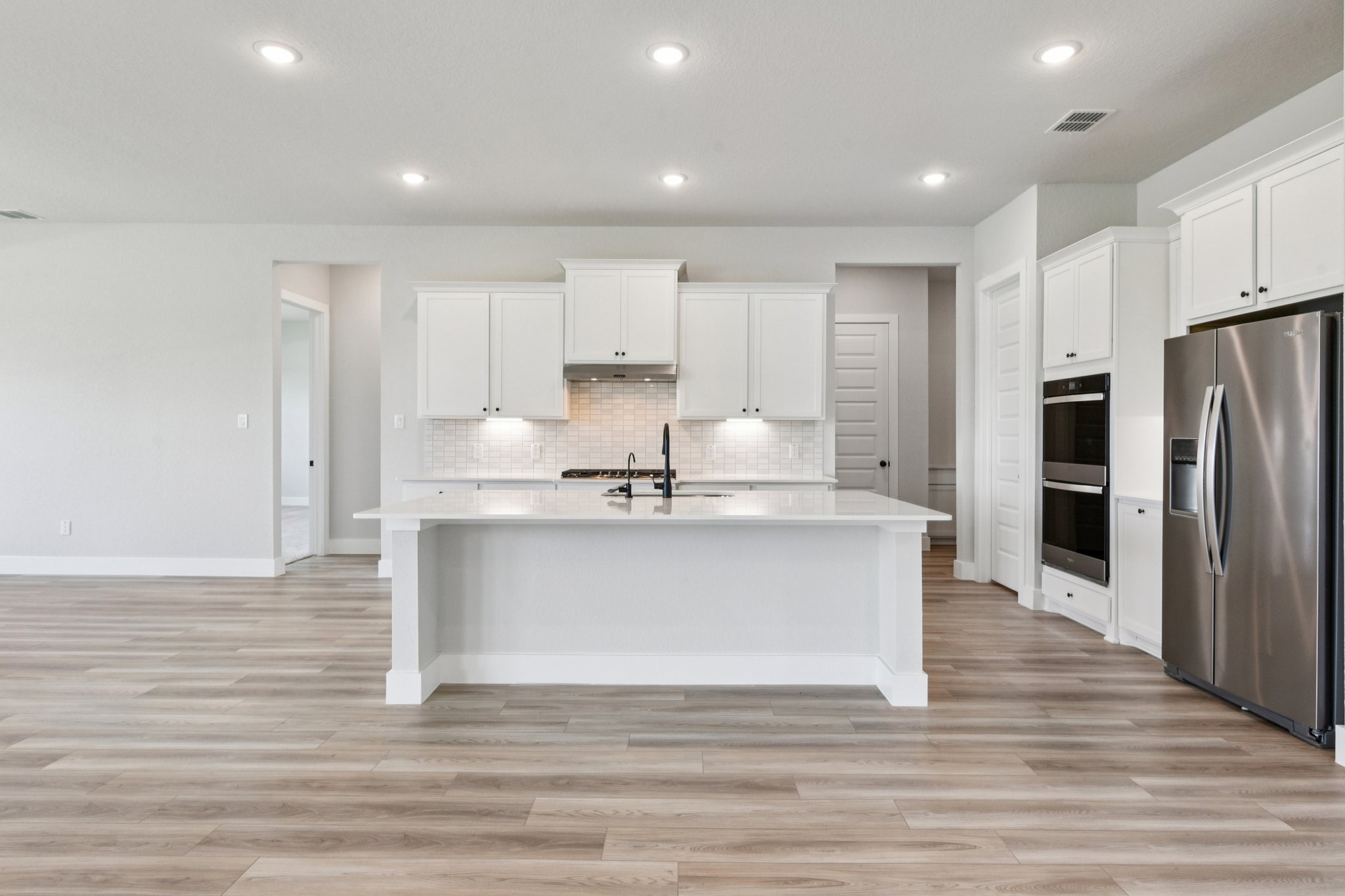 A kitchen with white cabinets.