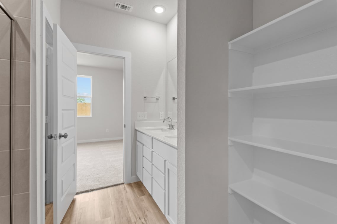 A bathroom with white cabinets.