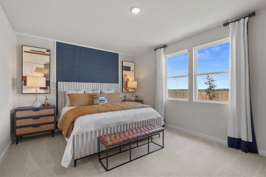 A bedroom with a bed and a bench.