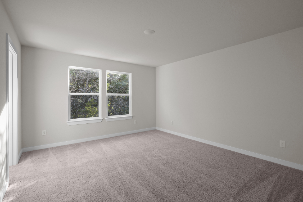 A room with a carpet and a window.