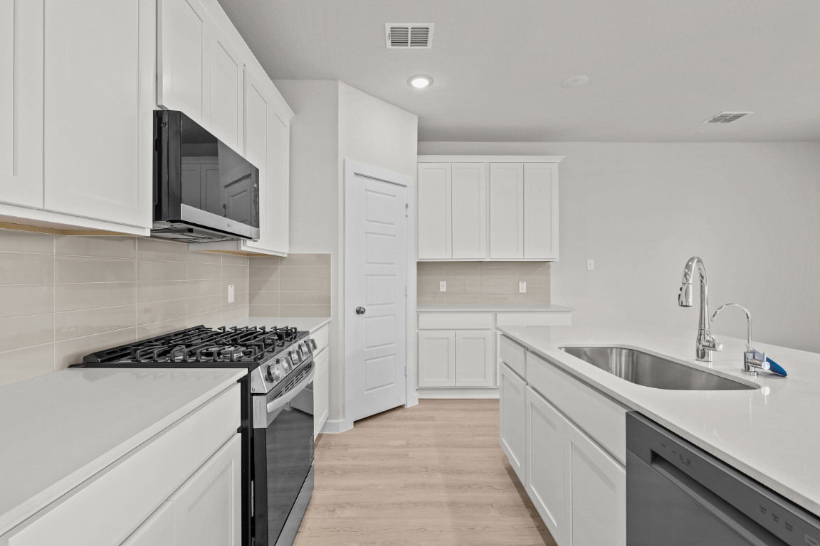 A kitchen with white cabinets.