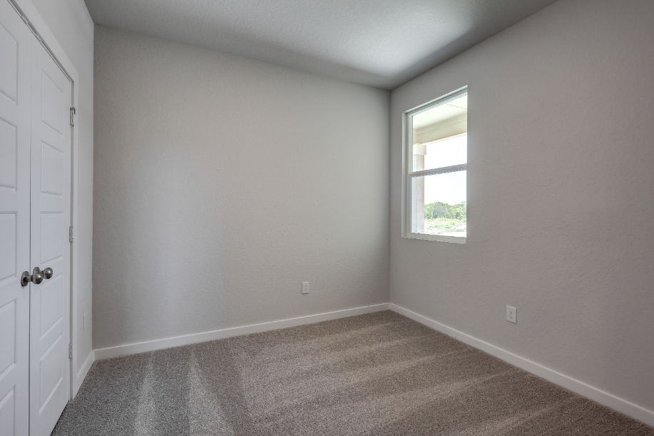 A room with a window and a carpet.