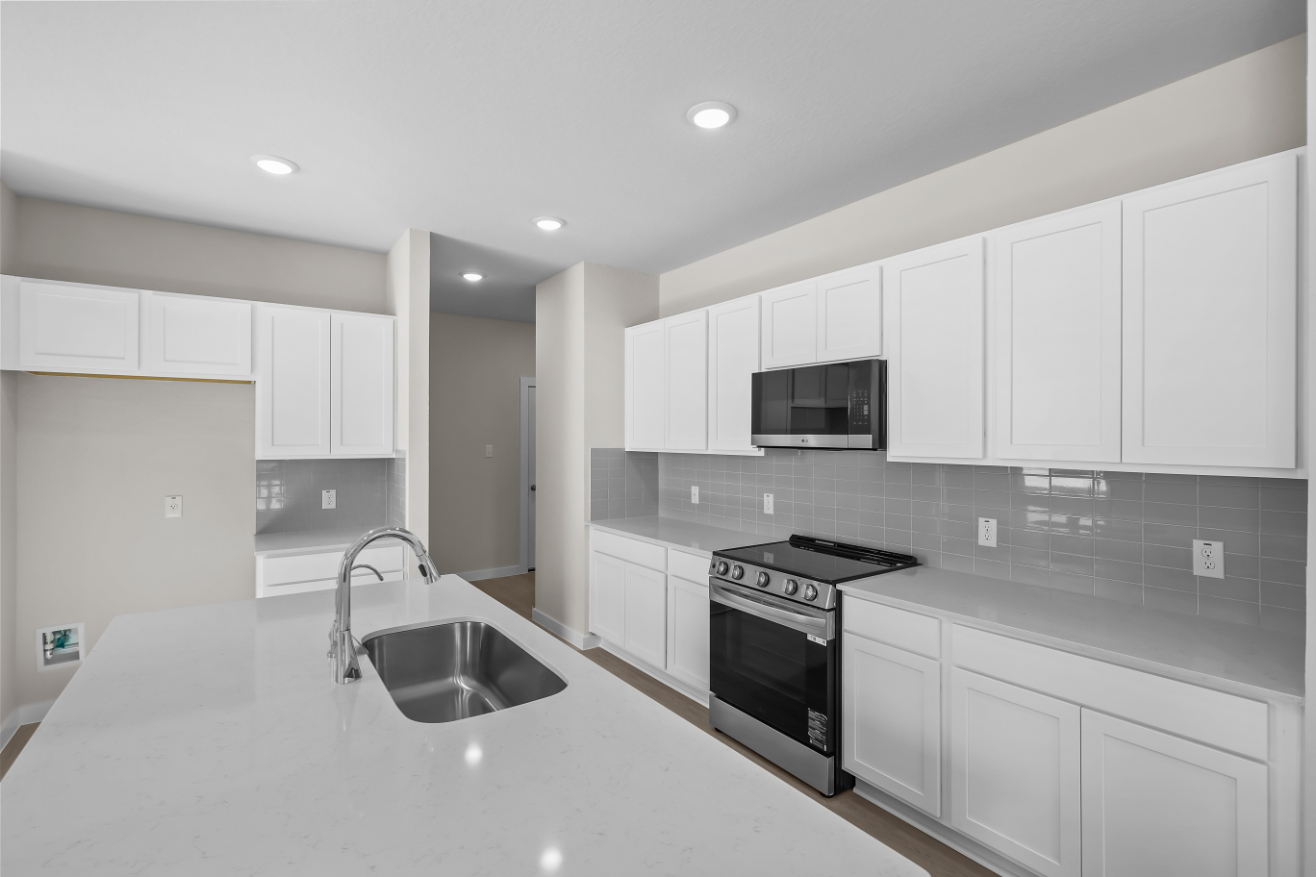 A kitchen with white cabinets.