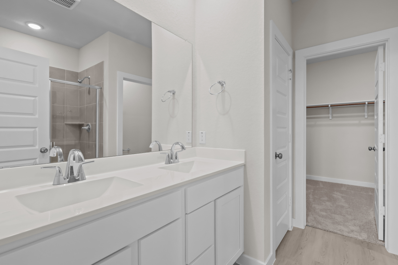 A bathroom with a sink and a shower unit.