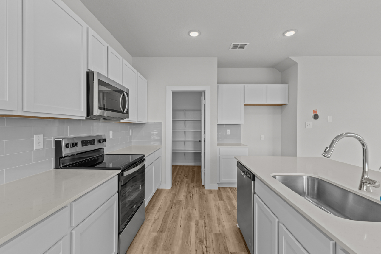 A kitchen with white cabinets.