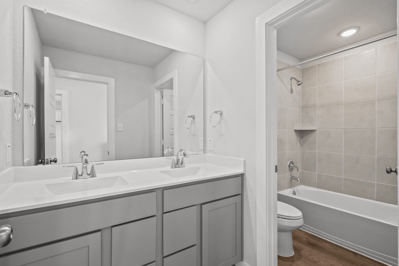 A bathroom with a tub sink and toilet.