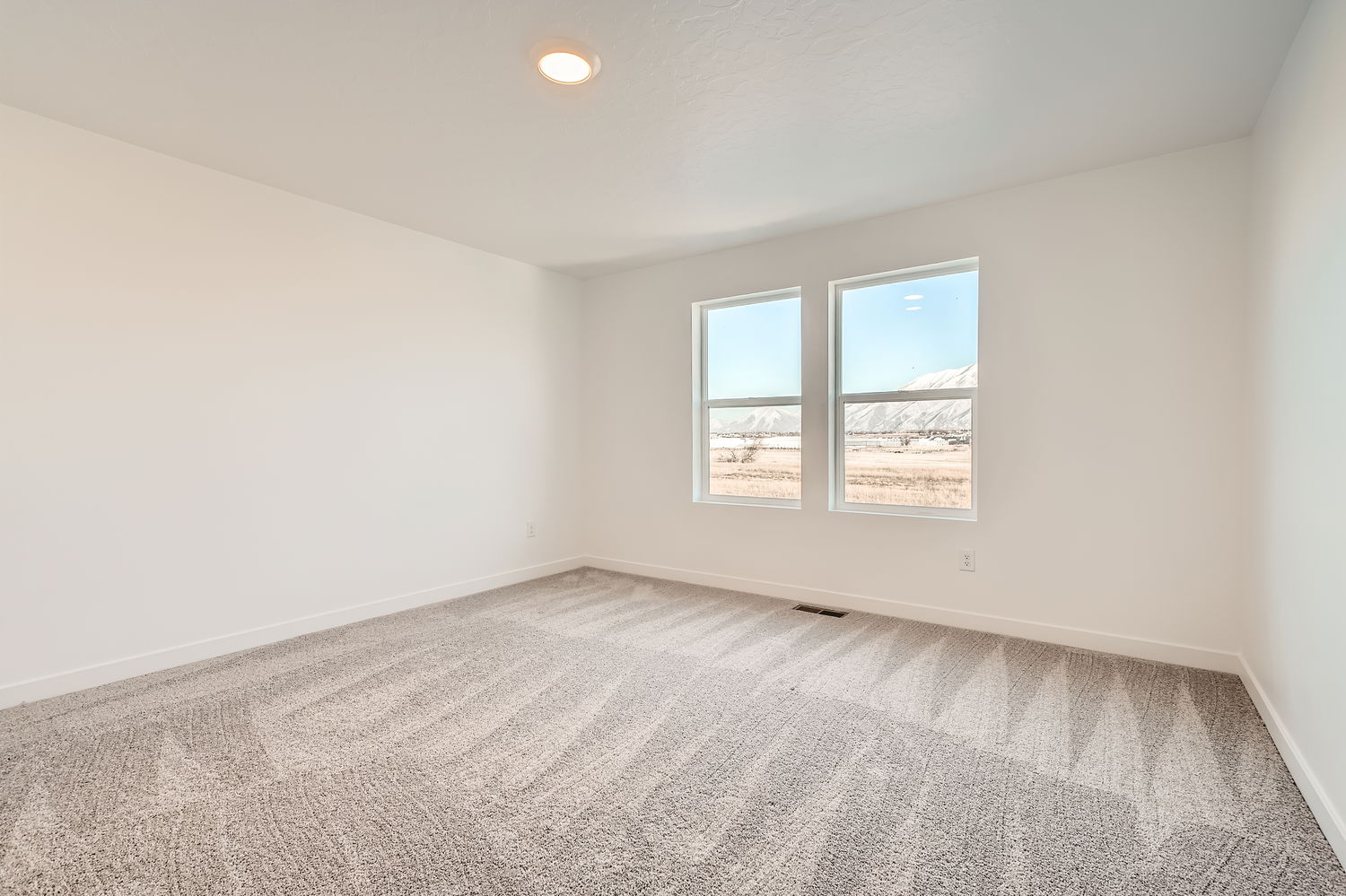 A room with a window and a carpet.