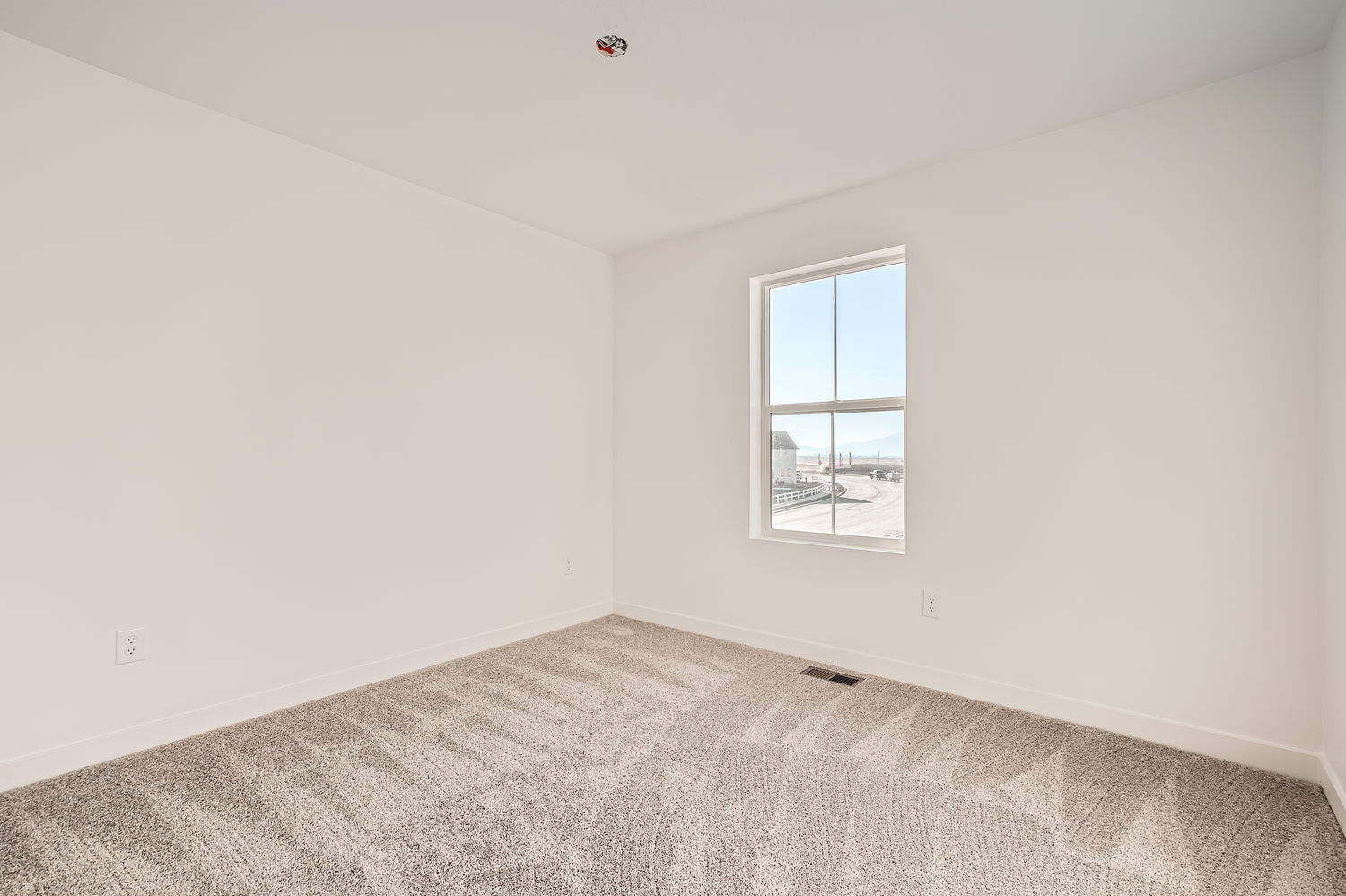 A room with a window and carpet.