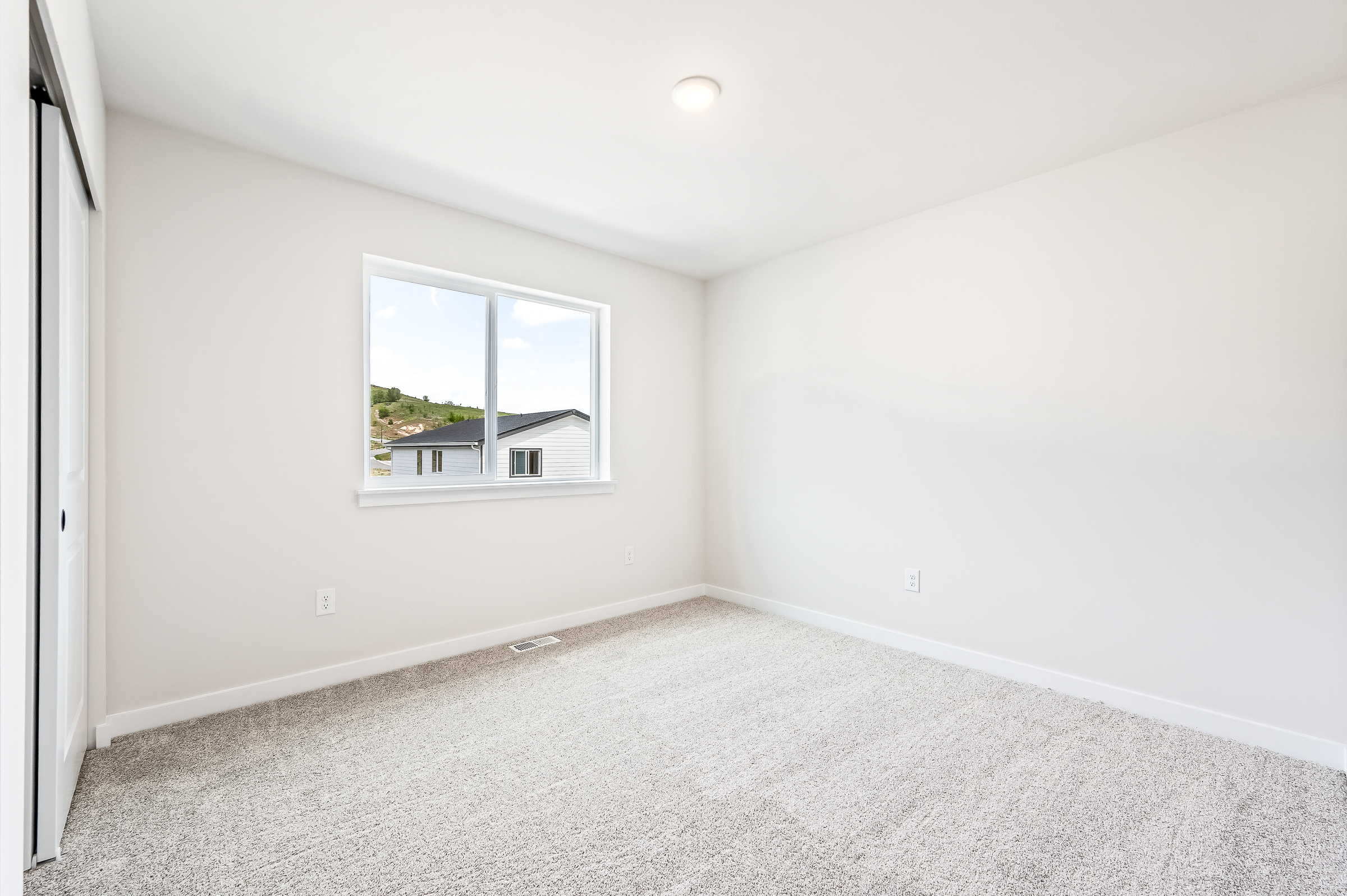 A room with a window and a carpet.