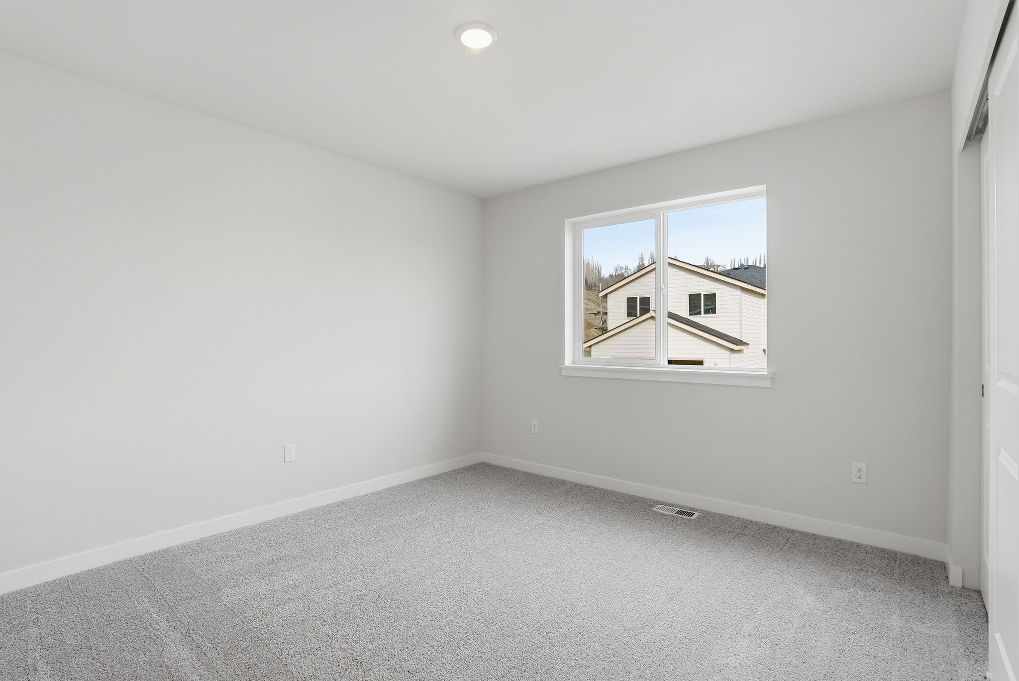 A room with a window and a carpet.