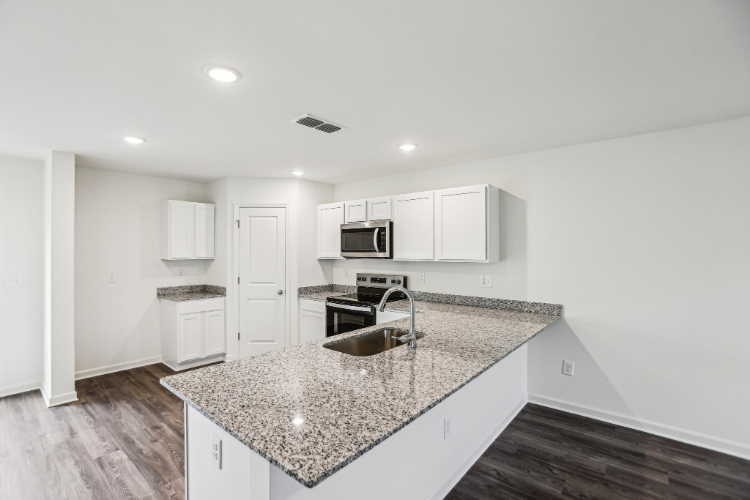 A kitchen with white cabinets.