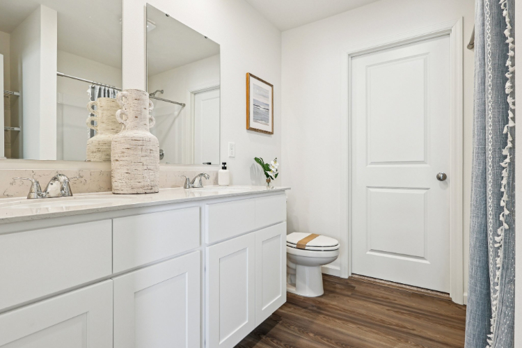 A bathroom with white cabinets.