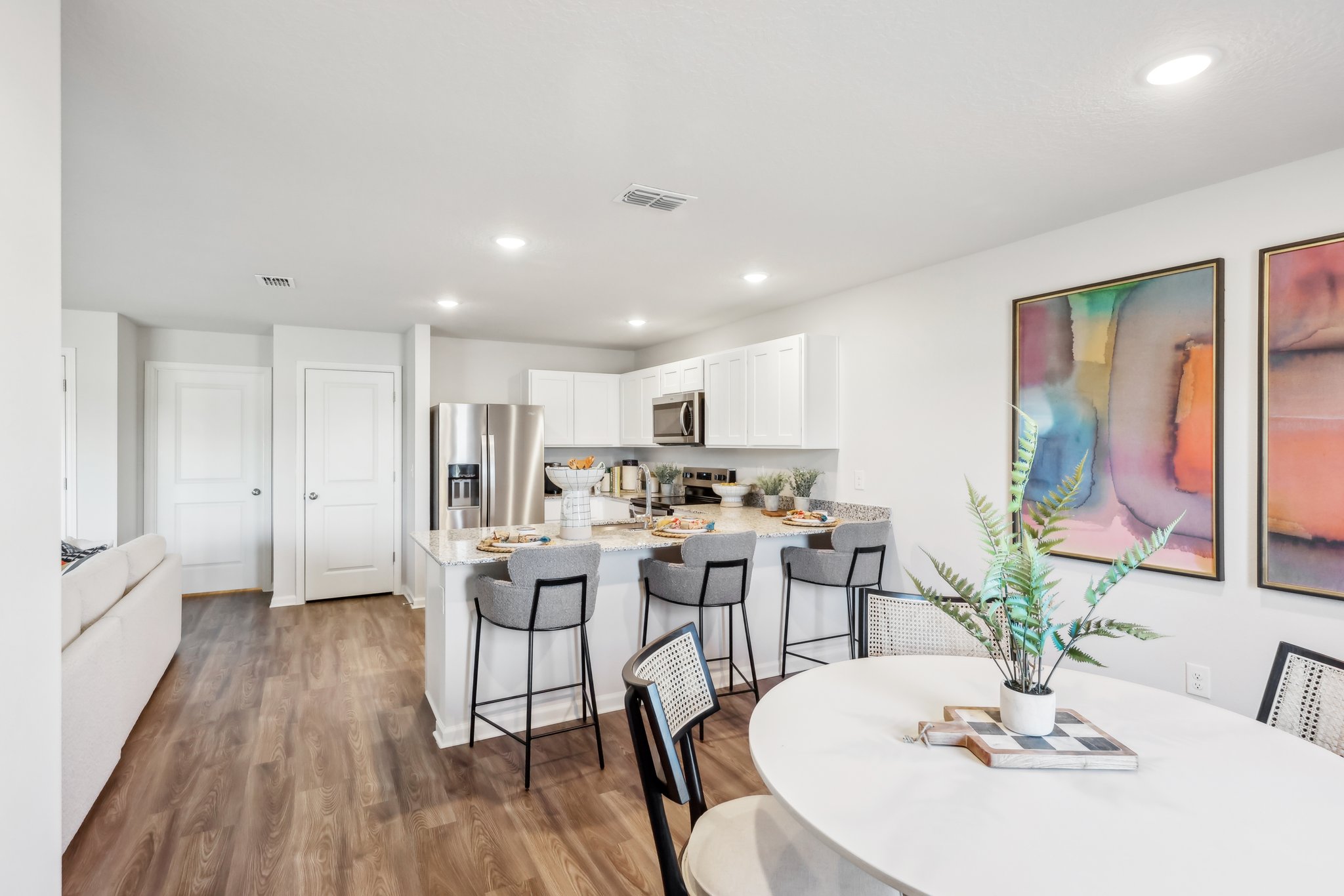 A kitchen with a dining table and chairs.