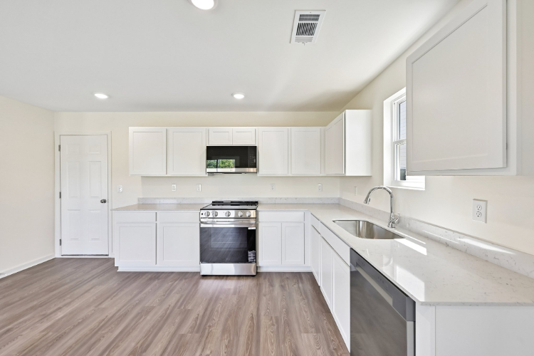 A kitchen with white cabinets.