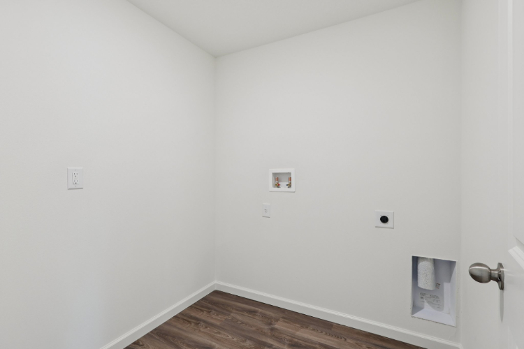 A white wall with a wood floor.