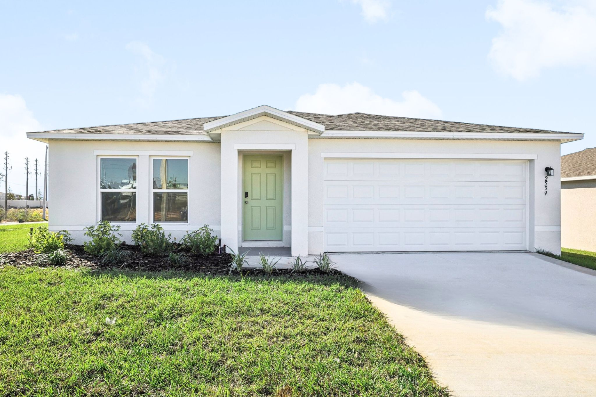 A white house with a green lawn.