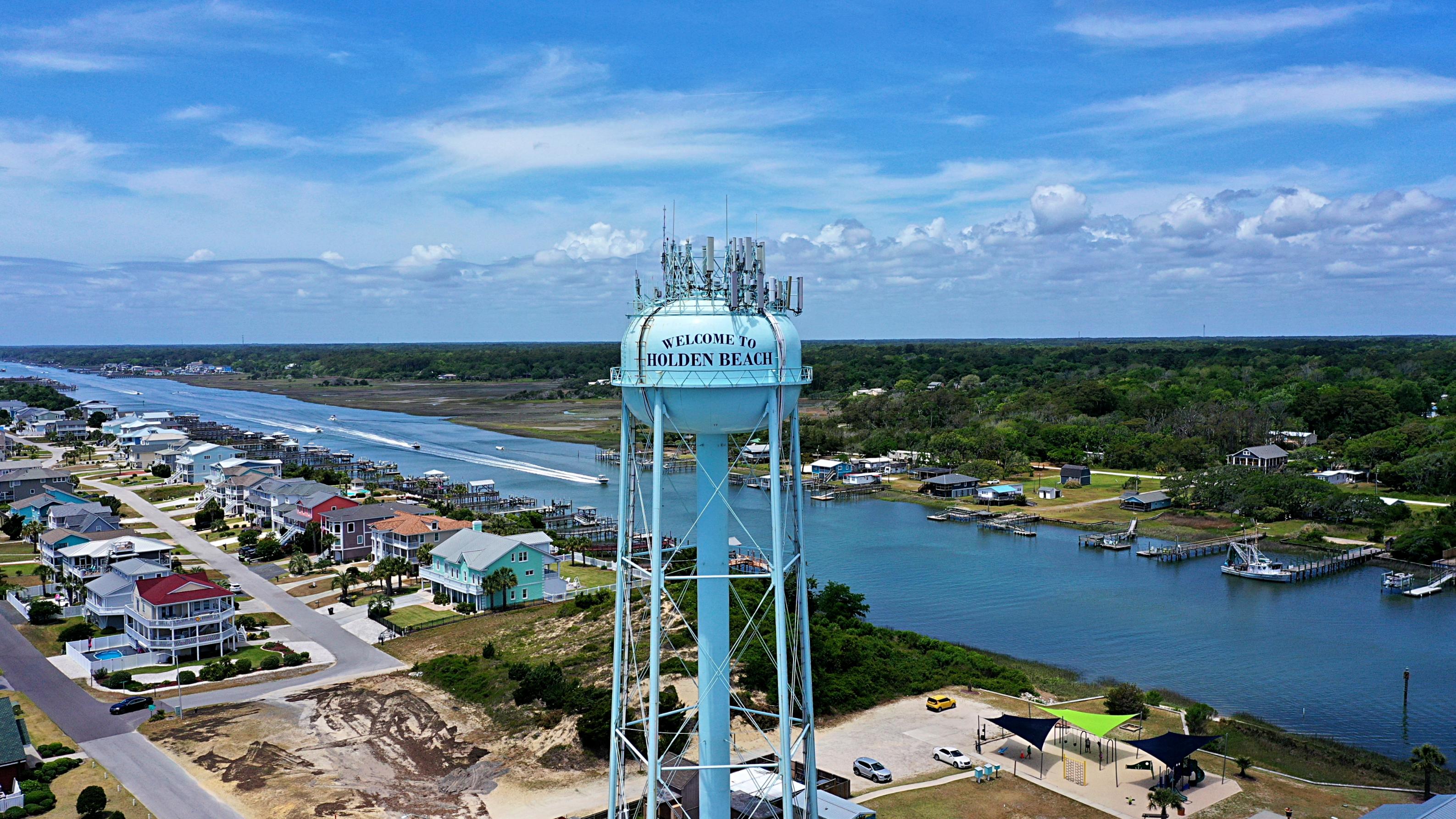 A large water tower next to a city.