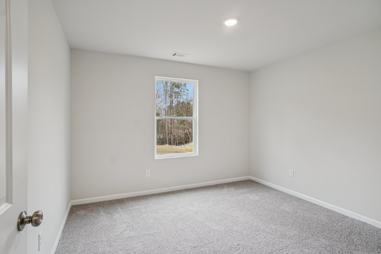 A room with a window and a carpet.