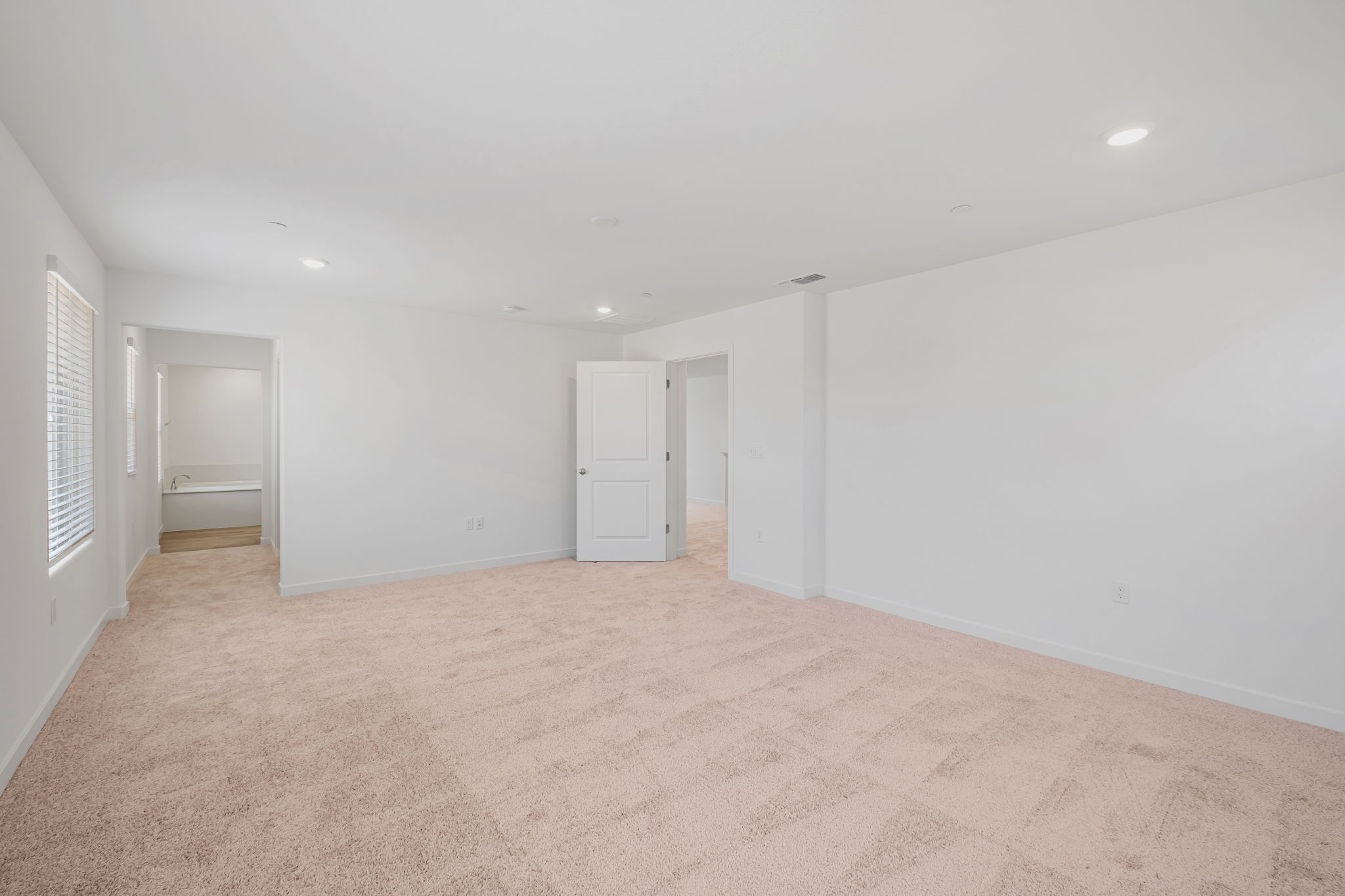 A long hallway with white doors.