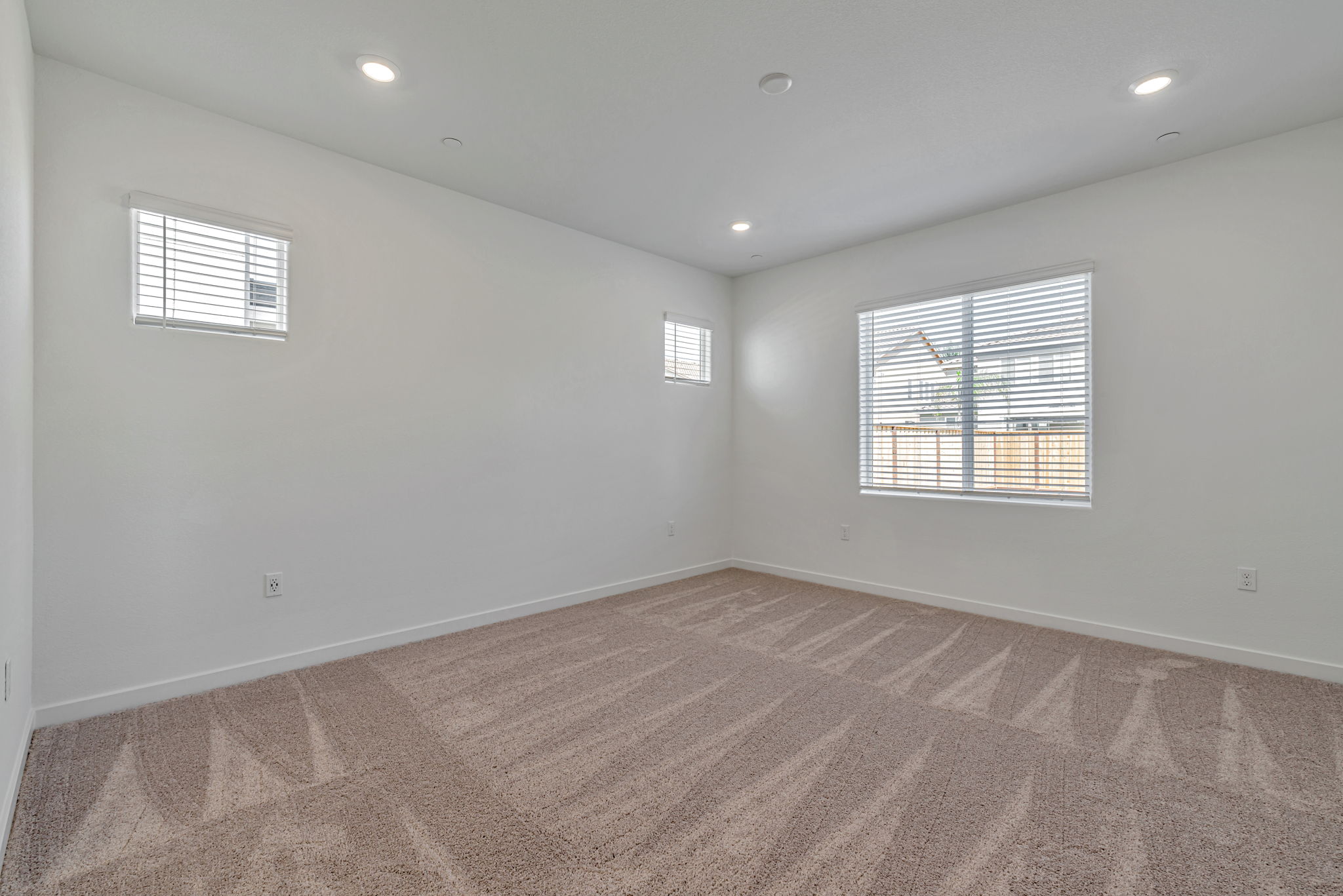 A room with a carpet and a window.