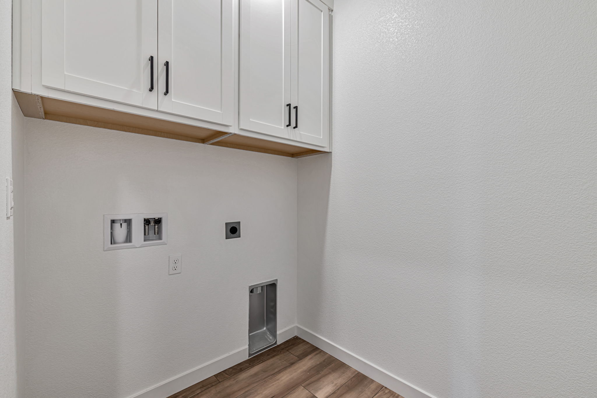 A white wall with white cabinets.